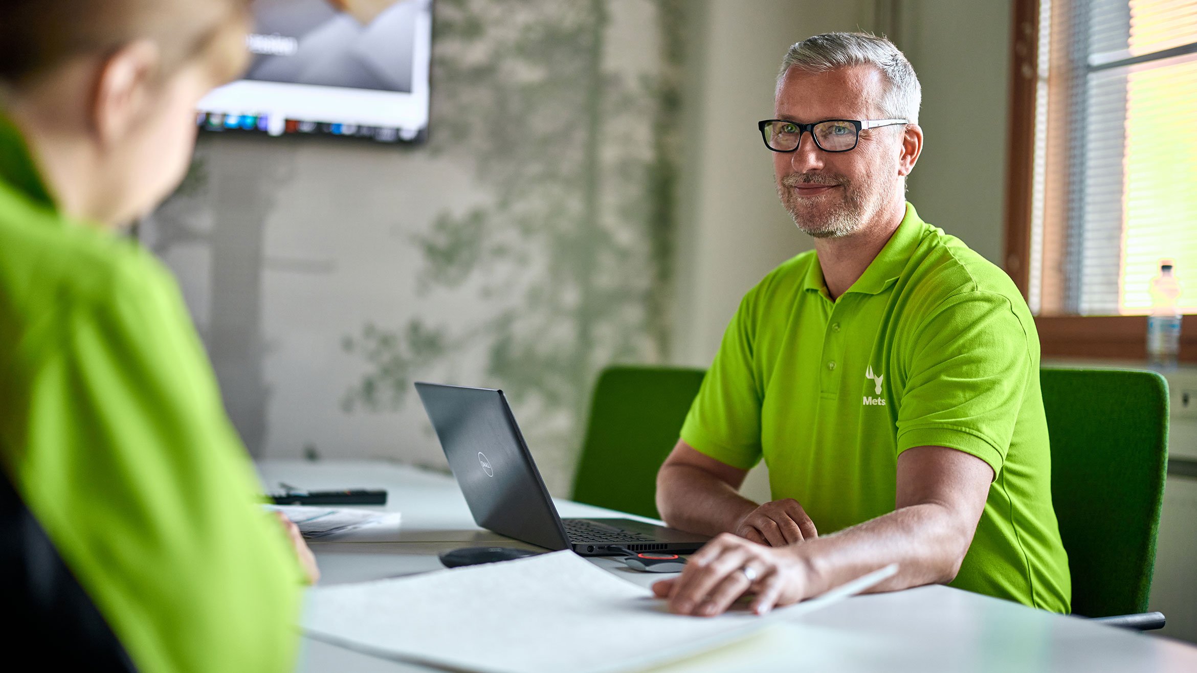 Man sits by a table in a meeting room