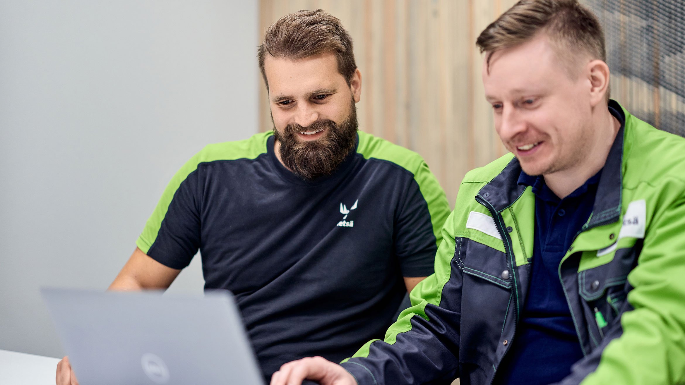 Two men looking at laptop image in a meeting room