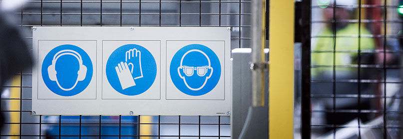 Safety information signs attached to safety fence in a production facility