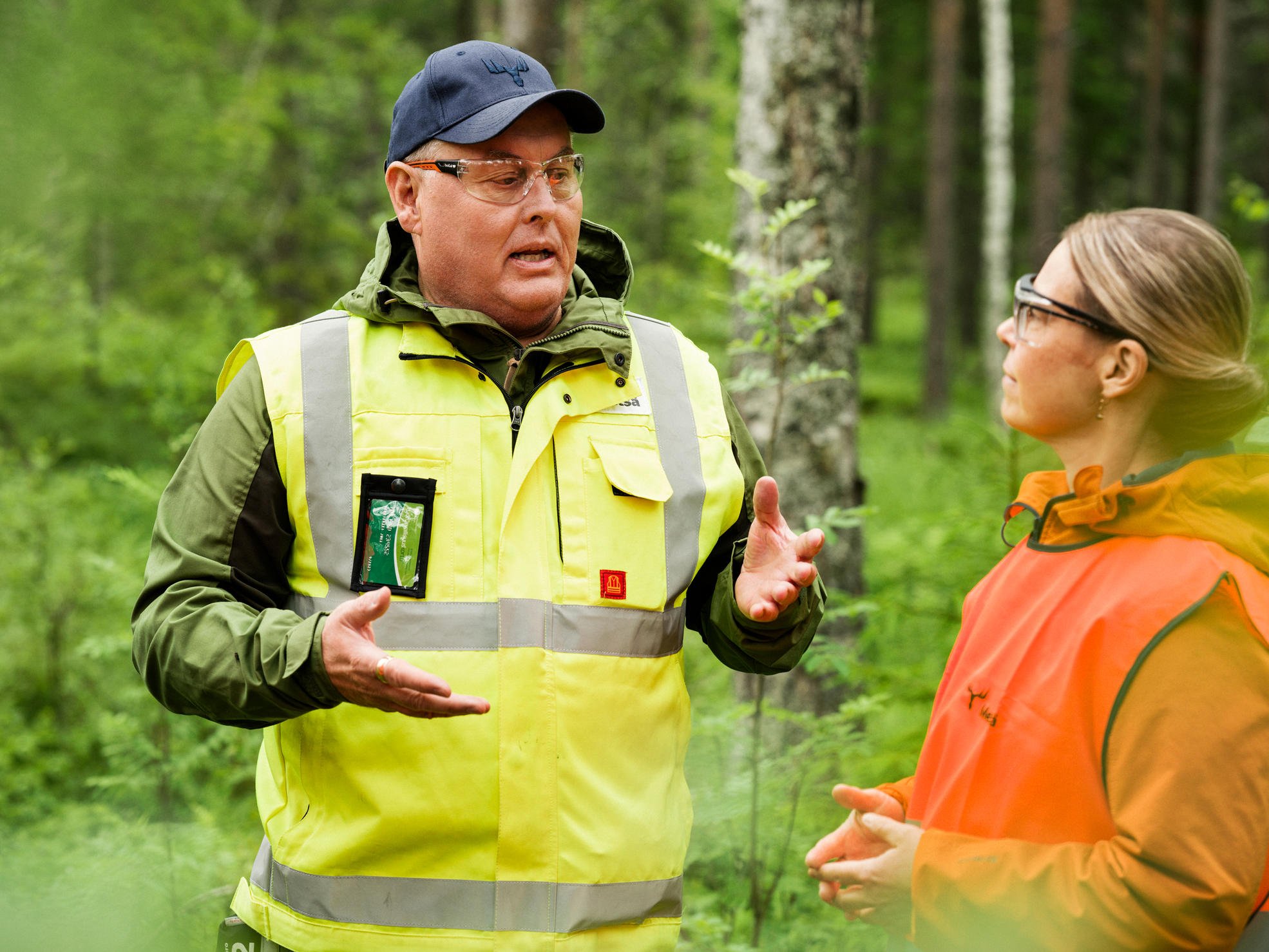 Skogsexpert diskuterar med skogsägare vid en avverkningsplats.