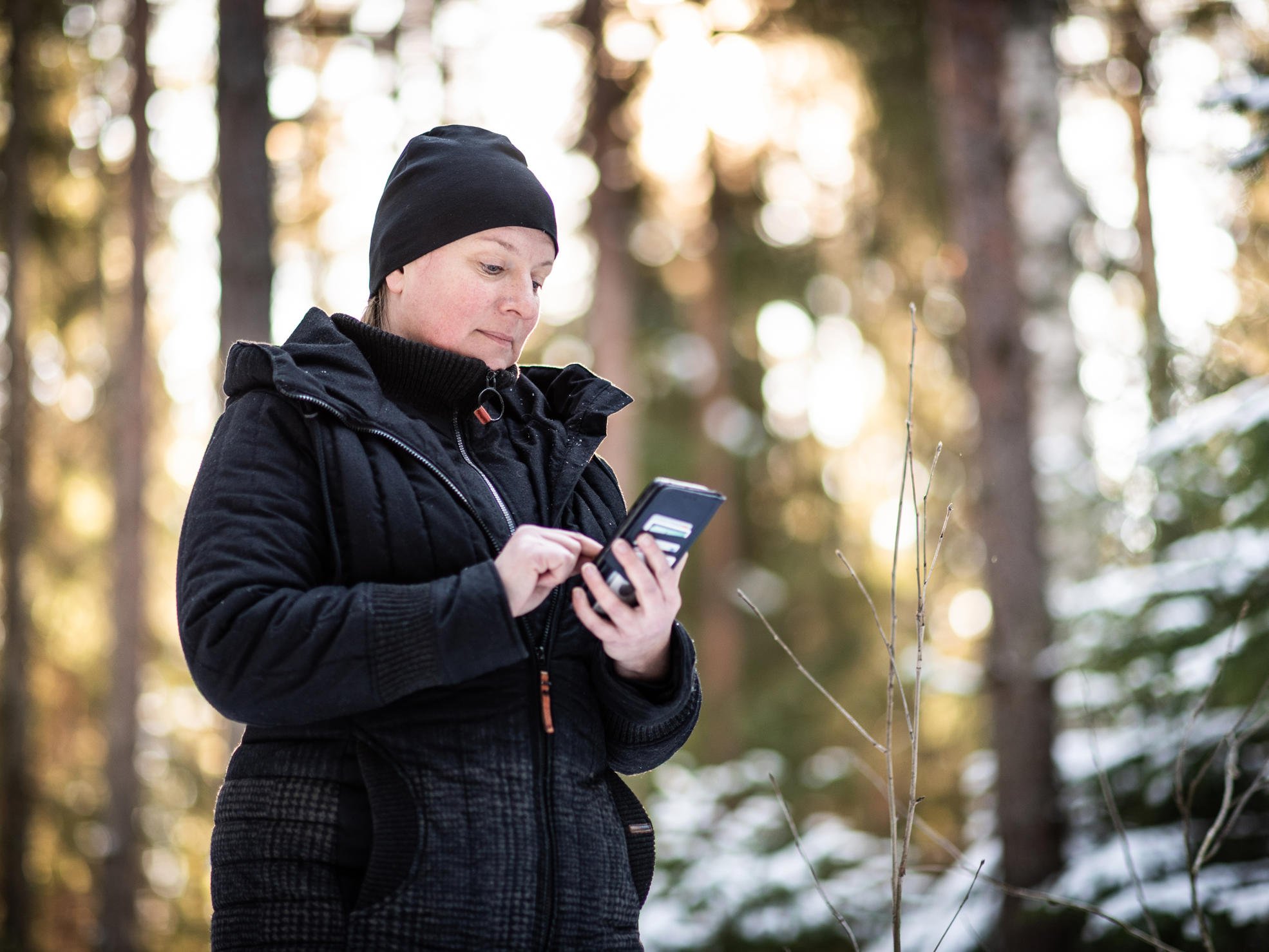 A woman standing in a misty forest, with trees floating in the air.