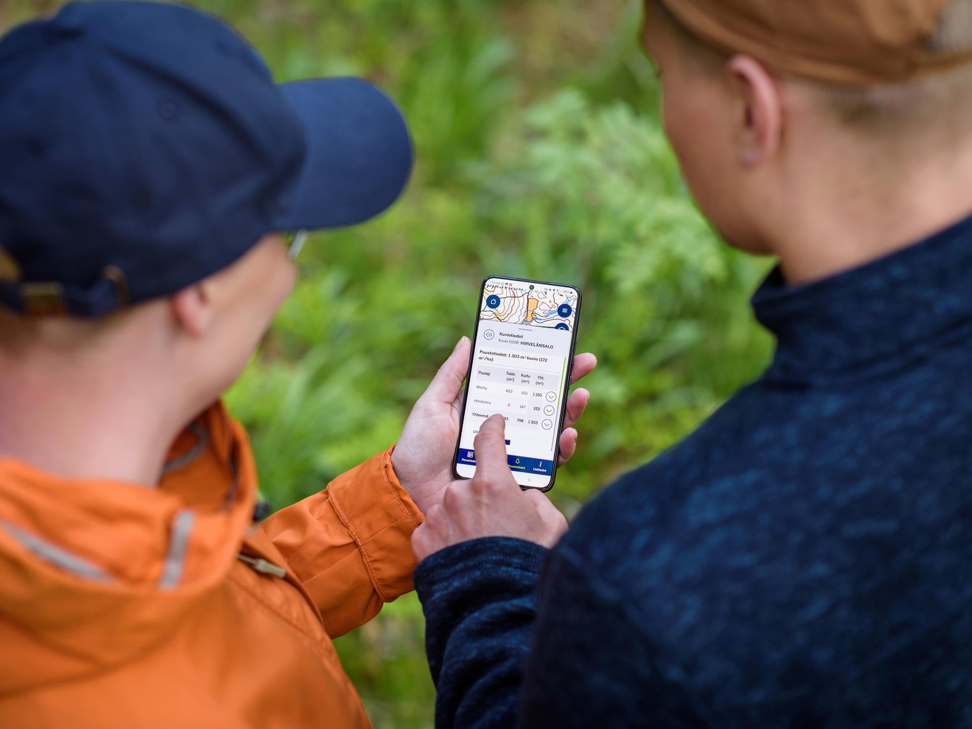 En skogsexpert och en skogsägare utforskar Metsäverkko på en telefonskärm.